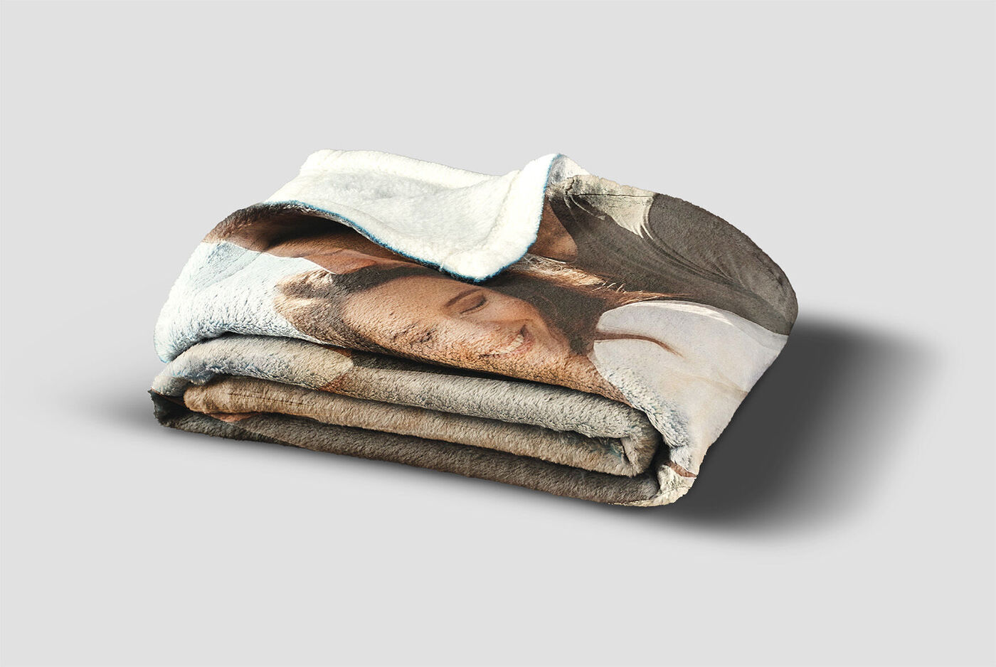 Una coperta piegata con una foto di momenti felici, ideale per un regalo.