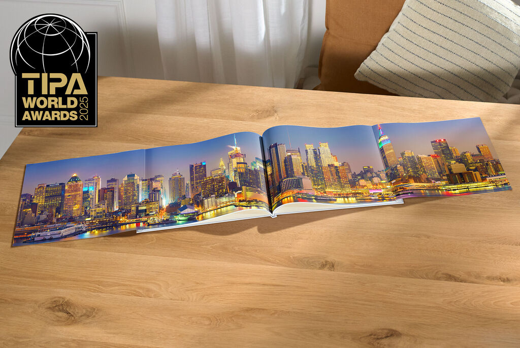 Un CEWE Fotobuch con una vista panoramica urbana aperto su un tavolo.
