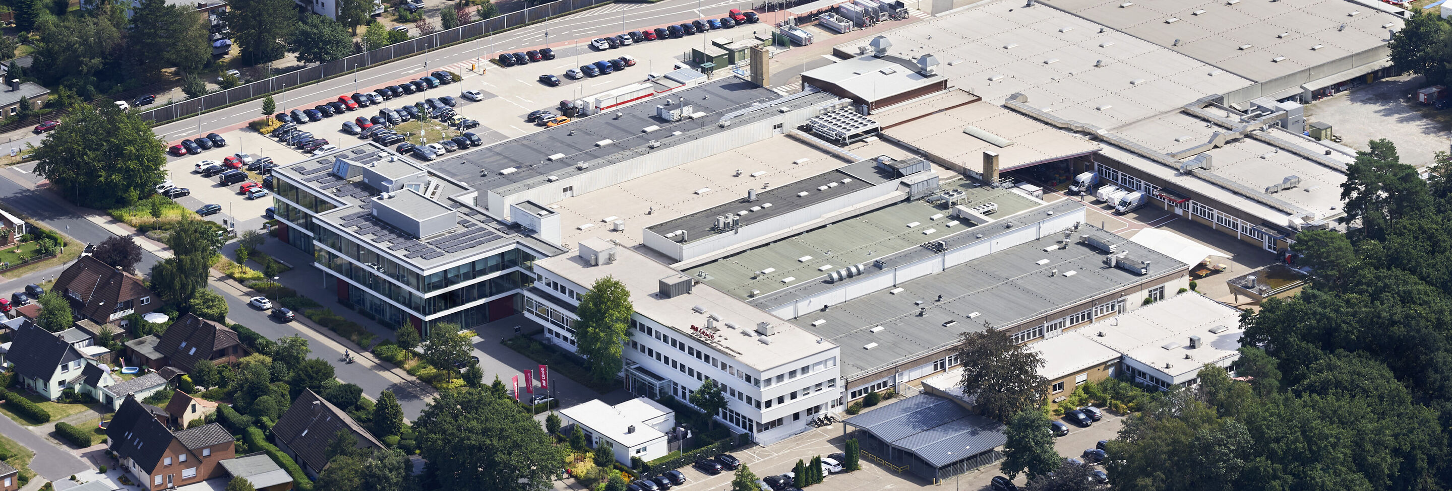 Ripresa aerea del complesso aziendale CEWE con diversi edifici e parcheggi.
