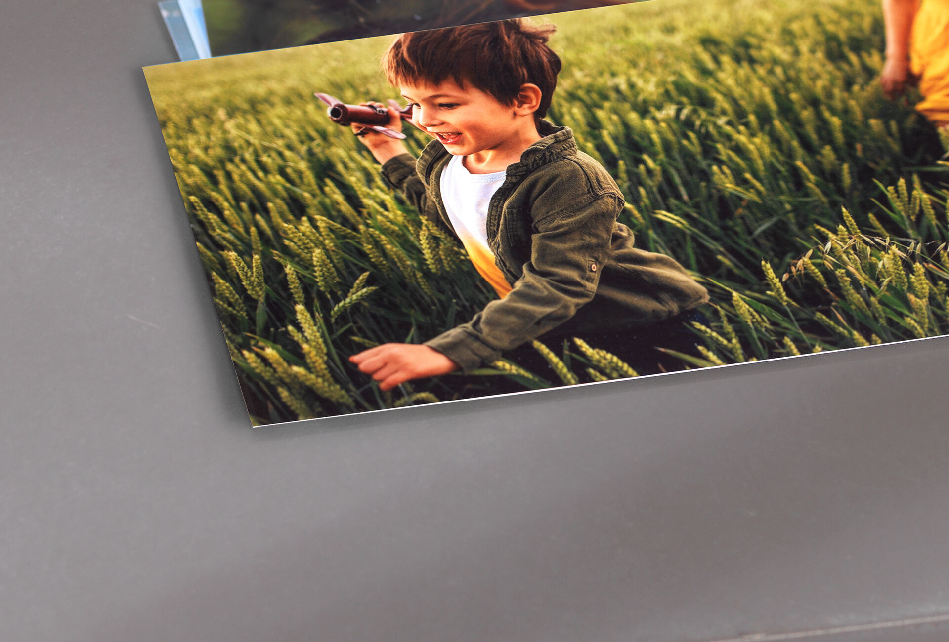 Un bambino con giocattolo in un campo di erba verde.