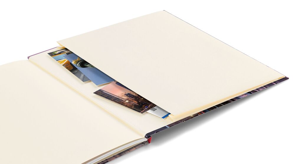 Un libro fotografico aperto con pagine vuote e foto inserite.