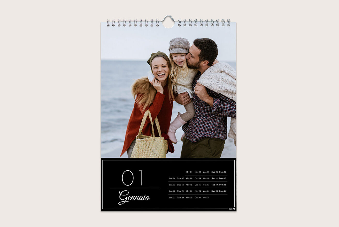 Famiglia in spiaggia con un calendario per gennaio.