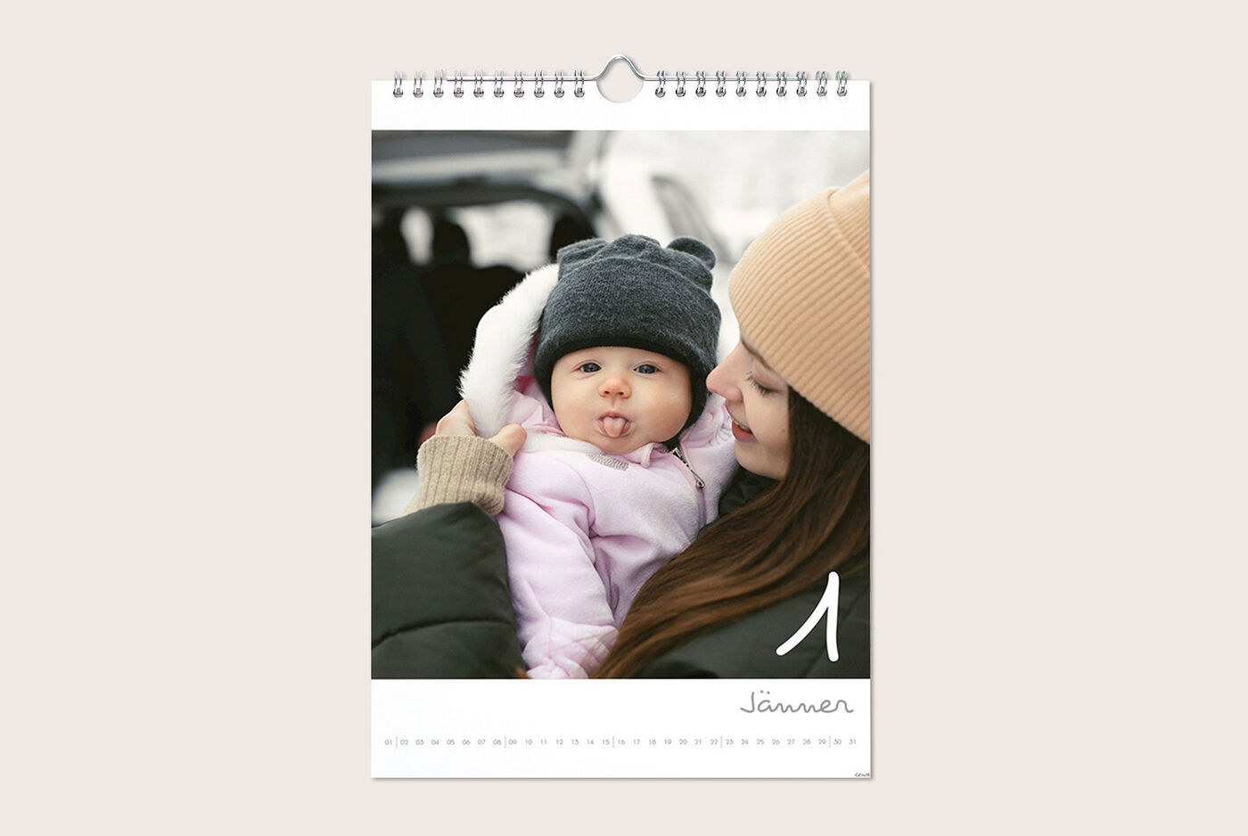 Una madre tiene il suo bambino a gennaio in un fotocalendario. Entrambi indossano abiti caldi.