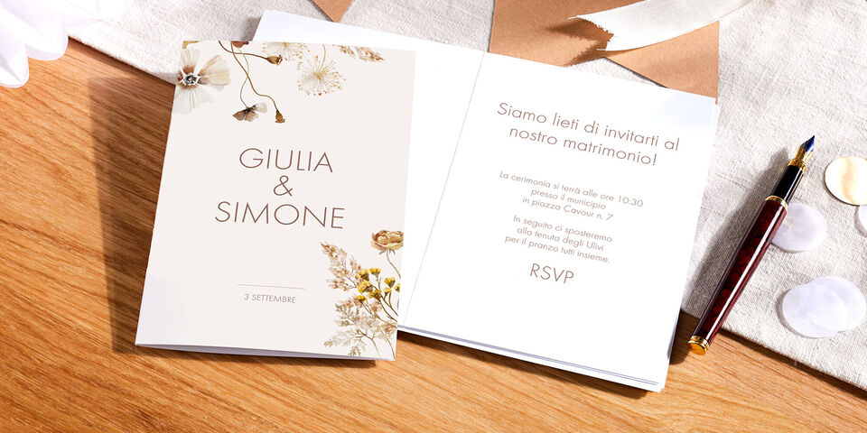 Elegante invito di matrimonio con motivi floreali e testo personalizzato.