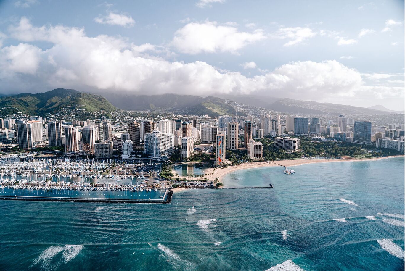 Ripresa aerea di Honolulu con spiaggia e nuvole sopra la città