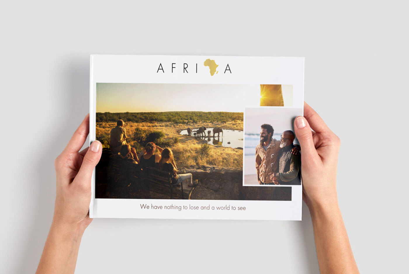 Una persona tiene in mano un fotolibro CEWE con ricordi dell'Africa