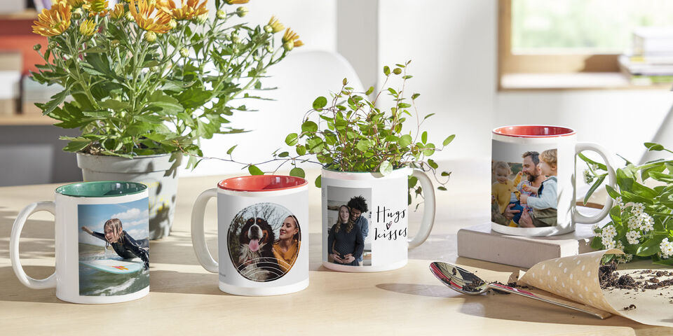 Quattro tipi di tazze personalizzate con foto di famiglia su un tavolo di legno.