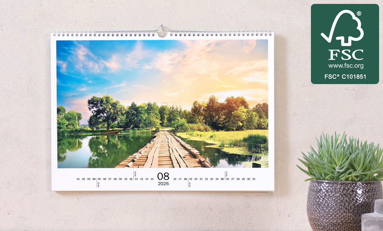 Calendario fotografico appeso mostra un paesaggio pittoresco con un pontile su acqua calma, circondato da verde lussureggiante