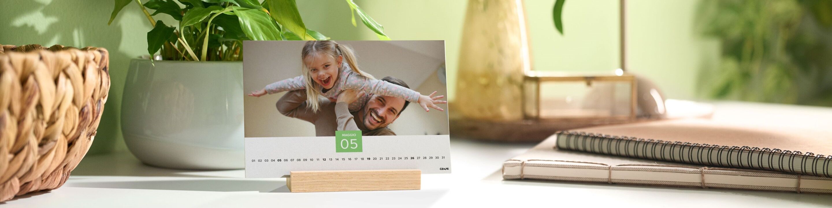 Un tavolo di calendario ben progettato su una scrivania neutra, circondato da una pianta.