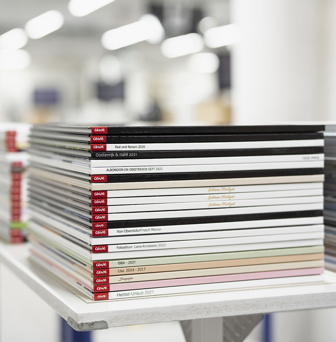 Libri fotografici CEWE impilati in vari colori e dimensioni
