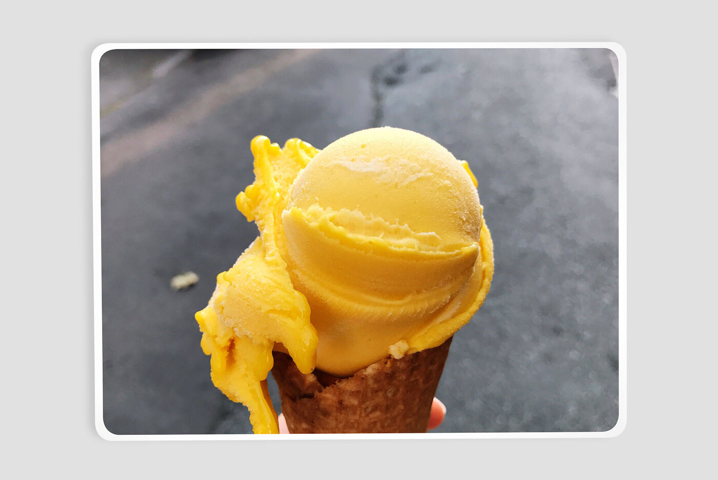 Una pallina gialla brillante e cremosa su un cono di gelato. Sembra deliziosa e rinfrescante.