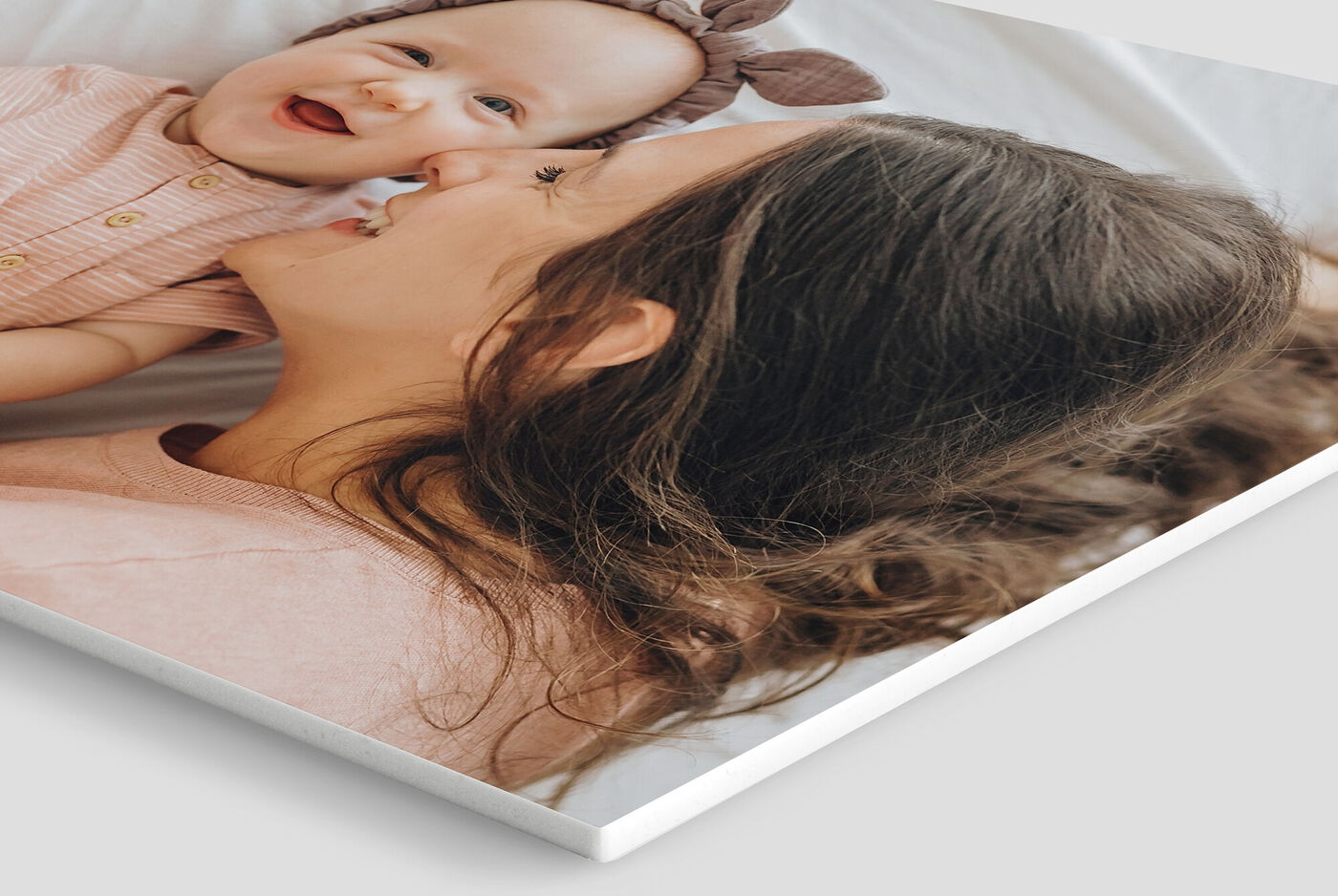 Madre sorridente con un bambino in braccio, entrambi felici e innamorati.