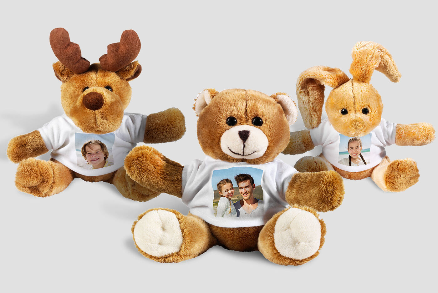 Tre peluche con foto sulle loro magliette, che irradiano gioia.