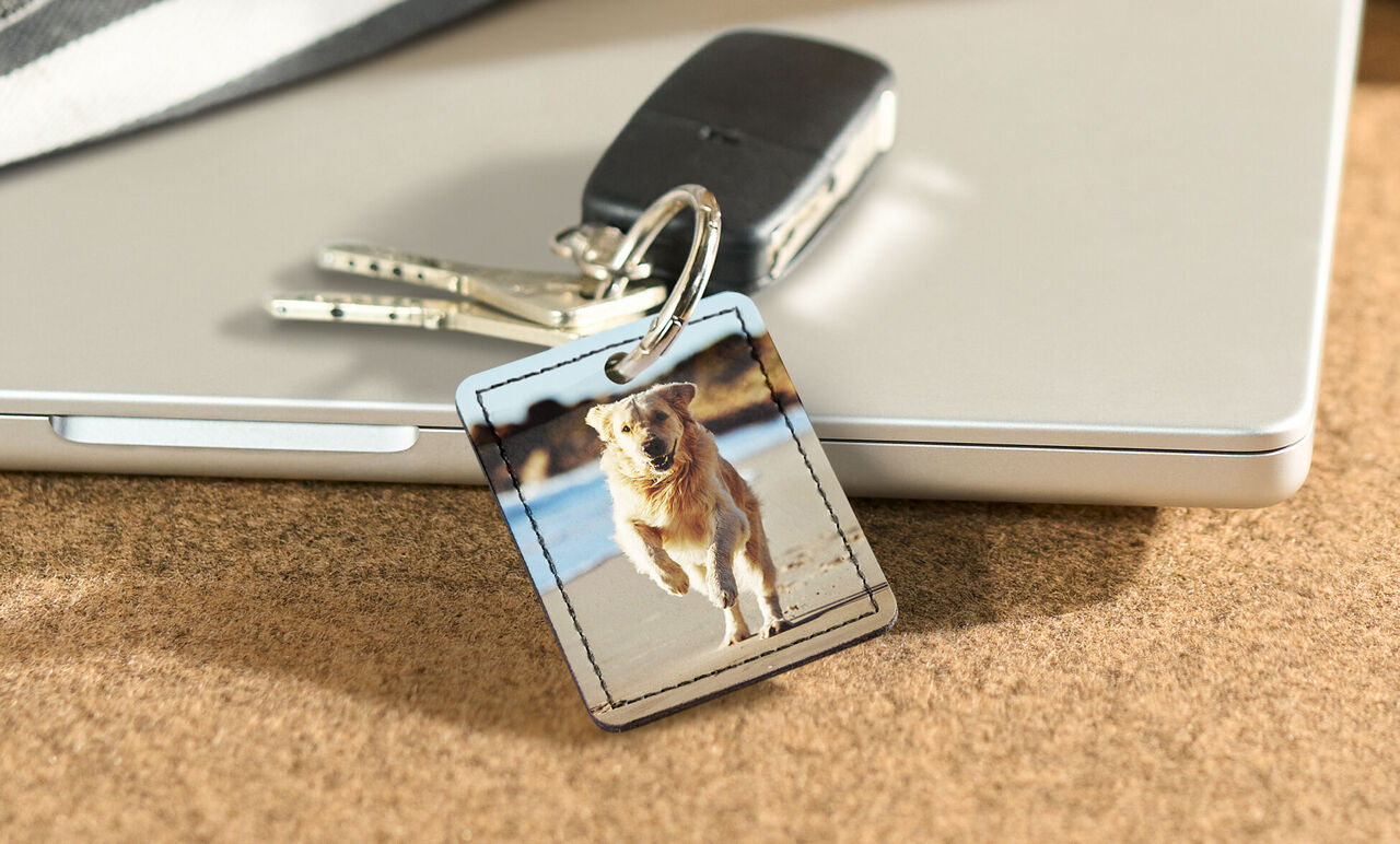 Un portachiavi con foto di un cane che corre sulla spiaggia